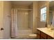 Bathroom features a shower with curtain, a bathtub, a window, a sink, and a toilet at 740 Obsidian Way, Durham, NC 27703