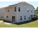 Two-story home featuring vinyl siding, solar panels, a small patio, a/c unit, and luscious green yard at 740 Obsidian Way, Durham, NC 27703