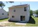 Back of home with solar panels on roof, patio area, sliding glass door, a/c unit and lush green lawn at 740 Obsidian Way, Durham, NC 27703