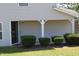 Charming home entrance featuring well-manicured bushes, a dark front door, and lush green lawn at 740 Obsidian Way, Durham, NC 27703