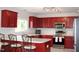 Well-lit kitchen with stainless steel appliances, cherry cabinets, and a breakfast bar at 740 Obsidian Way, Durham, NC 27703