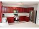 Modern kitchen with stainless steel appliances, cherry cabinets and ample countertop space at 740 Obsidian Way, Durham, NC 27703