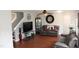 Spacious living room with hardwood floors, a large TV, and staircase access at 740 Obsidian Way, Durham, NC 27703