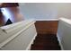 Staircase with white risers, dark treads, and white railing leading to the lower level at 740 Obsidian Way, Durham, NC 27703