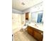 Well-lit bathroom featuring tile floors, a tub/shower, and a wood-look vanity at 75 Mountainside Ln, Sanford, NC 27332