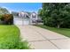 Long driveway leading to a two-story home with a two-car garage, a front porch, and mature trees at 75 Mountainside Ln, Sanford, NC 27332