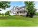View of the side of this two-story home with a front porch and a well-manicured lawn and mature trees at 75 Mountainside Ln, Sanford, NC 27332