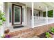 Covered front porch with white railings, brick steps, decorative glass front door and purple hydrangeas at 75 Mountainside Ln, Sanford, NC 27332