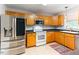 Bright kitchen with stainless steel refrigerator, wood cabinets, and stainless steel appliances at 75 Mountainside Ln, Sanford, NC 27332