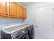 Bright laundry room featuring washer, dryer, and wooden cabinets for storage at 75 Mountainside Ln, Sanford, NC 27332