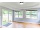 Bright living room featuring wood floors, large windows, and sliding glass door to the back yard at 75 Mountainside Ln, Sanford, NC 27332