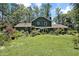 Beautiful backyard with lush lawn, mature trees, well-maintained landscaping, and a covered patio at 8156 Nc 42 Hwy W, Kenly, NC 27542