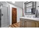 Bathroom features a glass shower and a wooden door, complementing the vanity and tile flooring at 8156 Nc 42 Hwy W, Kenly, NC 27542