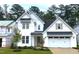 Beautiful two-story white home with a black metal awning, two-car garage, and well-manicured lawn at 9176 Dupree Meadow Dr # 17, Angier, NC 27501