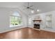 Bright and airy living room with a fireplace, large windows, a ceiling fan, and beautiful flooring at 100 Culbreth Rd # C, Chapel Hill, NC 27516