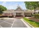 Community clubhouse featuring attractive brick accents, manicured landscaping, and ample parking at 10310 Sablewood Dr # 111, Raleigh, NC 27617