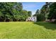 A large, grassy backyard with mature trees surrounds the home, creating a private retreat at 104 Benedict Ln, Raleigh, NC 27614