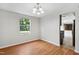 Cozy dining area showcasing wood flooring, a charming chandelier, and large window with views of the greenery at 104 Benedict Ln, Raleigh, NC 27614