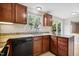 Stylish kitchen with granite counters, wood cabinetry, and a black dishwasher, combining functionality and aesthetics at 104 Benedict Ln, Raleigh, NC 27614