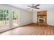 Inviting living room featuring hardwood floors, brick fireplace, and french doors to outdoor deck at 104 Benedict Ln, Raleigh, NC 27614