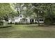 Charming single-story home with a lush green lawn and mature trees surrounding the property at 105 Litchfield Ct, Rocky Mount, NC 27803