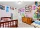 Bright bedroom with pink walls, a wooden bed frame, and charming decor and collectibles at 107 Canyon Run, Cary, NC 27513