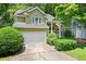 View of a charming two-story home with a well-manicured lawn, lush shrubs, and an attached two-car garage at 107 Canyon Run, Cary, NC 27513
