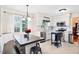 Bright eat-in kitchen with stainless steel appliances and a dark wood table surrounded by white cabinets and natural light at 107 Canyon Run, Cary, NC 27513
