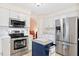 Bright kitchen with stainless steel appliances, white cabinetry, countertop island, and plenty of storage space at 107 Canyon Run, Cary, NC 27513