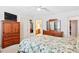 Well-lit bedroom with a floral-patterned bed, ceiling fan, and traditional wooden furniture at 107 Canyon Run, Cary, NC 27513