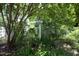 Backyard setting showcasing a charming birdhouse amid mature trees and lush greenery at 109 Perry Farms Dr, Apex, NC 27502