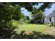 Spacious, shaded backyard with mature trees, lush lawn, and a partial view of the house at 109 Perry Farms Dr, Apex, NC 27502