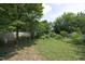Spacious backyard with lush lawn, mature trees, and surrounding wooden fence at 109 Perry Farms Dr, Apex, NC 27502