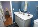 Bathroom vanity with gray cabinets, white countertop, blue walls and bedroom view at 109 Perry Farms Dr, Apex, NC 27502