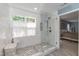 Modern bathroom with a glass-enclosed shower, window, and designer finishes at 11217 Maplecroft Ct, Raleigh, NC 27617