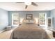 Comfortable bedroom featuring a ceiling fan, two windows, and neutral color palette at 11217 Maplecroft Ct, Raleigh, NC 27617