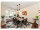 Elegant dining room with large window, modern chandelier, and seating for six at 11217 Maplecroft Ct, Raleigh, NC 27617
