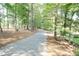 Scenic driveway lined with mature trees, providing a picturesque entrance to the property at 11217 Maplecroft Ct, Raleigh, NC 27617