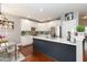 Bright kitchen boasts white cabinets, stainless appliances, and a contrasting dark blue island with marble countertop at 11217 Maplecroft Ct, Raleigh, NC 27617