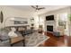 Cozy living room features a gray sectional, fireplace with mantle, and hardwood floors at 11217 Maplecroft Ct, Raleigh, NC 27617