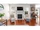 Inviting living room showcasing a fireplace with decor, large windows, and hardwood flooring at 11217 Maplecroft Ct, Raleigh, NC 27617