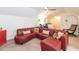 Cozy living room with a plush red sectional, a study area, and a vintage mini fridge at 11217 Maplecroft Ct, Raleigh, NC 27617