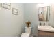 Stylish powder room with a floating vanity, modern fixtures and decorative artwork creating a serene ambiance at 11217 Maplecroft Ct, Raleigh, NC 27617