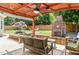 Backyard patio featuring an outdoor seating area with an overhead fan, fireplace, and water feature at 113 Sycamore Ridge Ln, Holly Springs, NC 27540