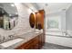 Elegant bathroom featuring double sinks, granite countertops, and a decorative window above the tub at 113 Sycamore Ridge Ln, Holly Springs, NC 27540