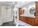 Luxurious bathroom with double sinks, granite countertops, stone wall, and a glass-enclosed shower at 113 Sycamore Ridge Ln, Holly Springs, NC 27540