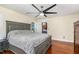 Comfortable bedroom with a large bed, hardwood floors, and a stylish ceiling fan at 113 Sycamore Ridge Ln, Holly Springs, NC 27540