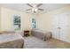 Inviting bedroom featuring twin beds, neutral carpet and plenty of natural light from the windows at 113 Sycamore Ridge Ln, Holly Springs, NC 27540
