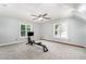Bright bonus room with neutral carpet, large windows, and a ceiling fan, perfect for a home gym at 113 Sycamore Ridge Ln, Holly Springs, NC 27540