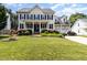 Traditional two-story home with a manicured lawn, black shutters, and an attached two-car garage at 113 Sycamore Ridge Ln, Holly Springs, NC 27540